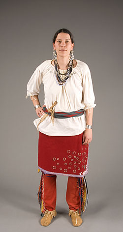 model wearing white tunic and red skirt, woolen leggings, and moccasins