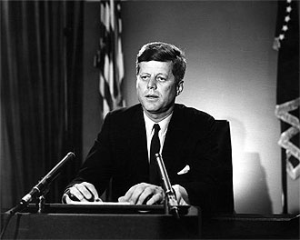 file:/activities/oralhistory/cappics/elliot1945_kennedy, alt: president kennedy speaking from a podium