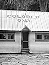 jim crow housing - cabin with the words colored only painted on roof
